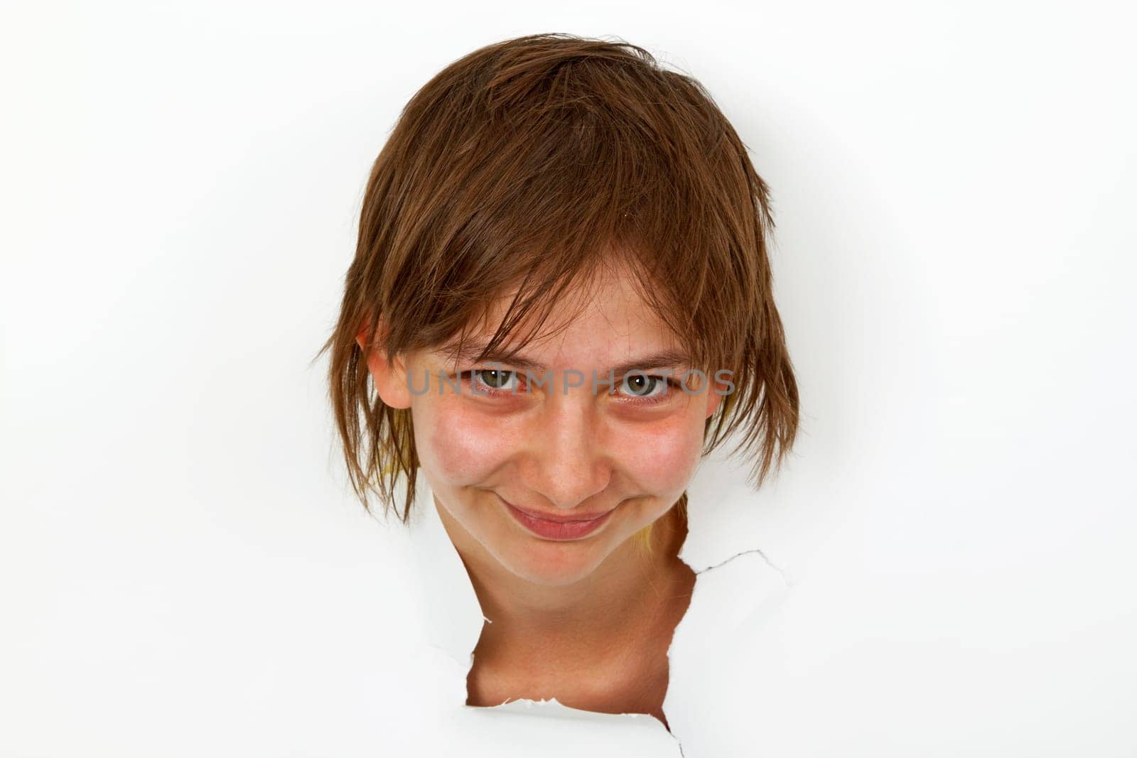 Young woman looking out of white paper