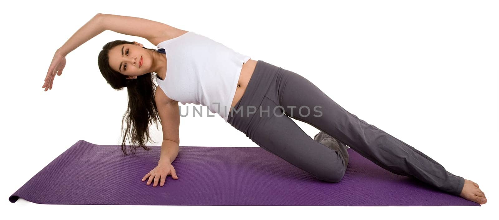 A young beautiful brunette is exercising and stretching.