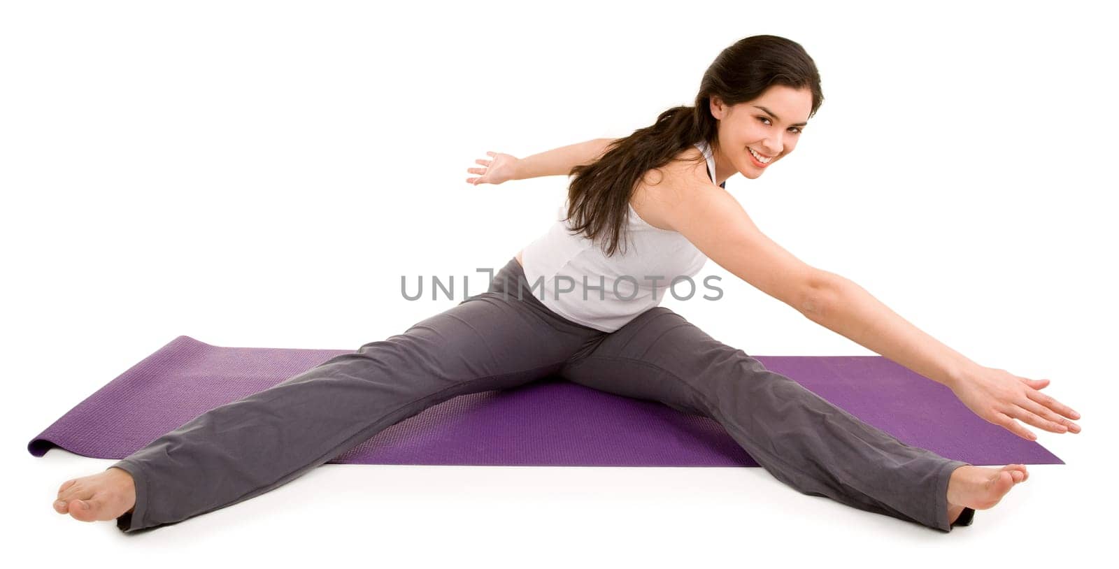 A young beautiful brunette is exercising and stretching.