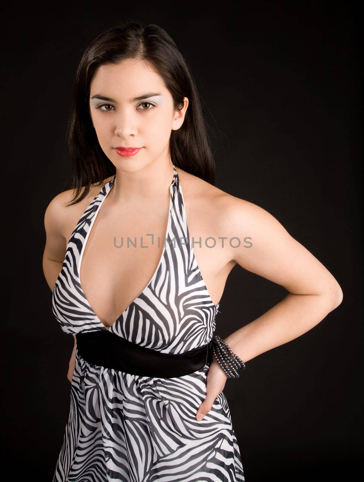 A beautiful young lady in a black and white dress looking at the camera.