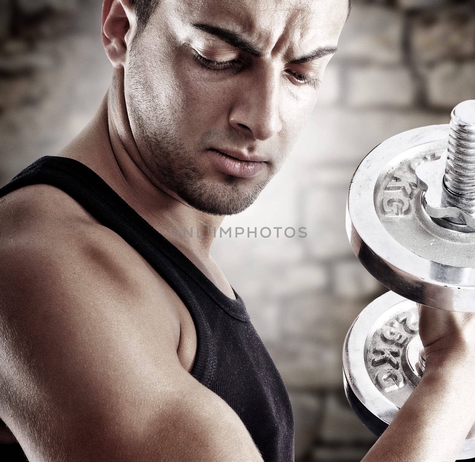 Young man doing weights lifting on stone background