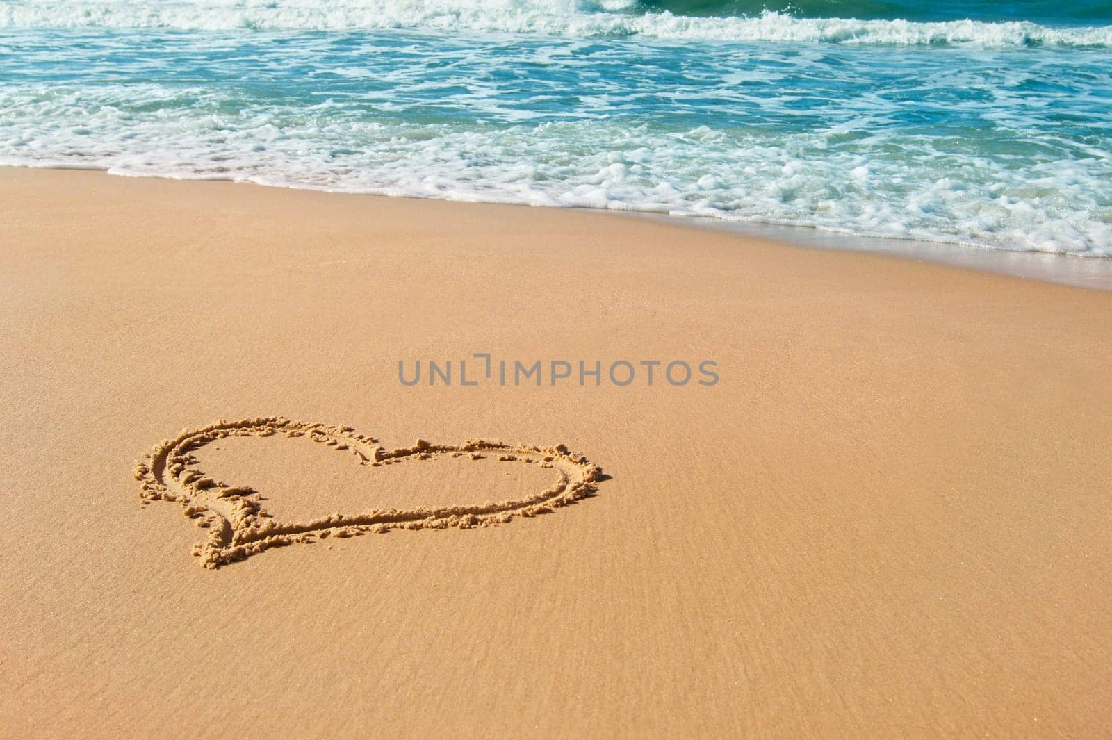 Heart drawn on beach sand, summer love