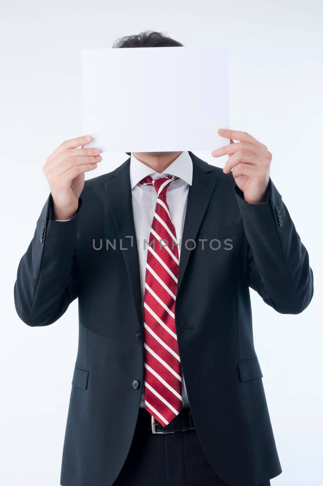 Businessman holding an empty advert in front of his face