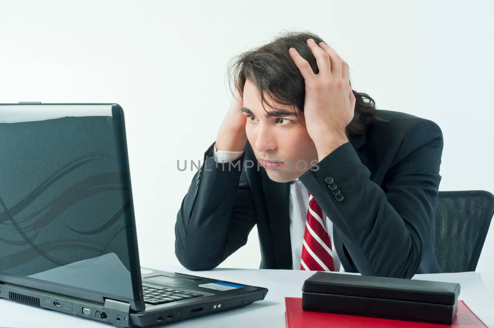 Man worried sitting on his desk in front of a notebook