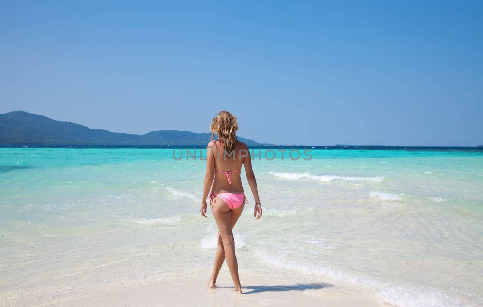 Young woman stading on a stunning turquoise beach