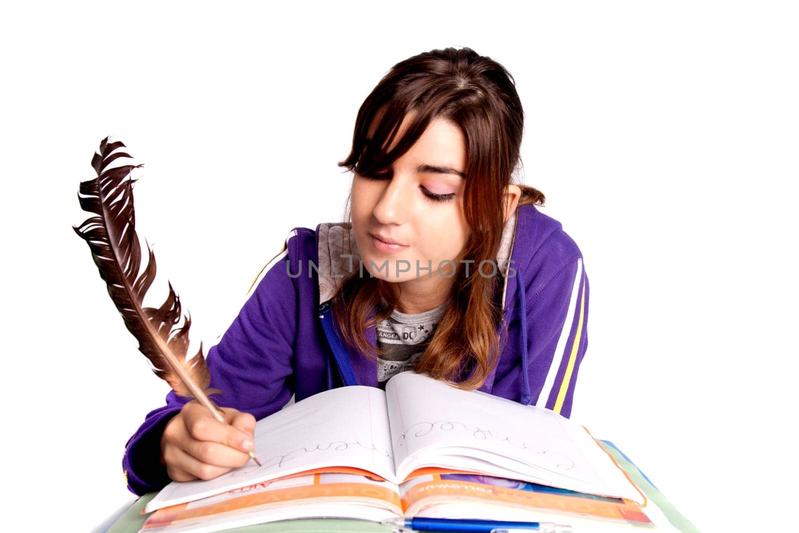 View of a teenager school girl writing on the book with a feather pen.