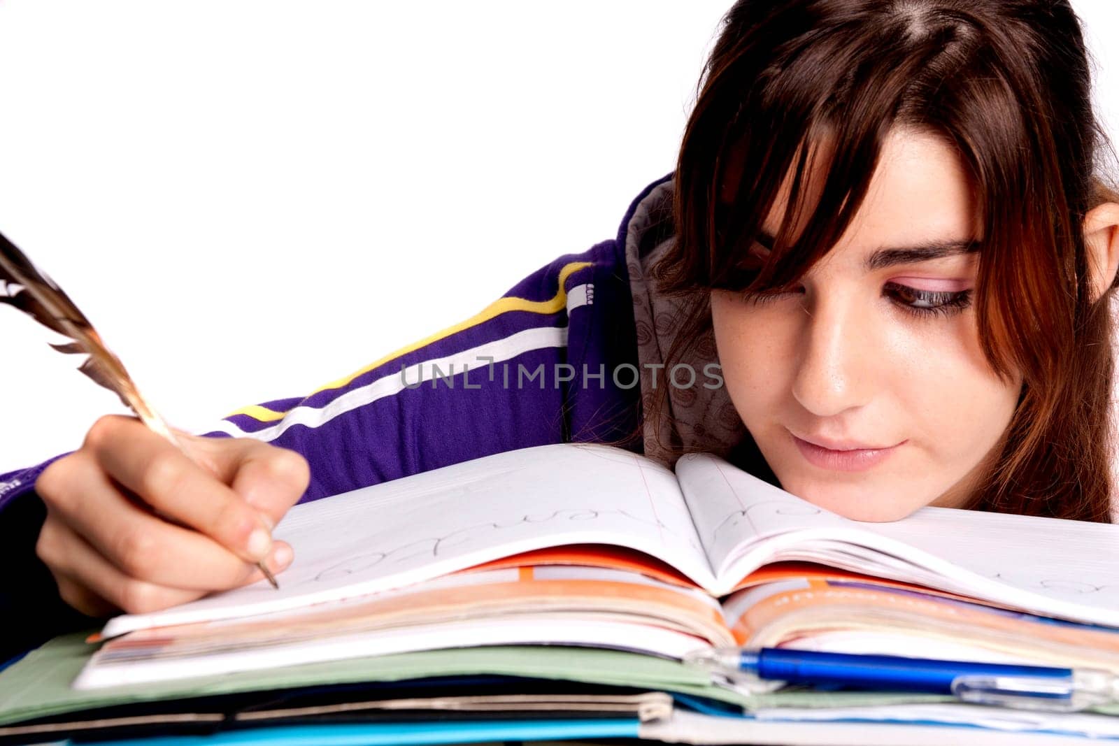 View of a teenager school girl writing on the book with a feather pen.