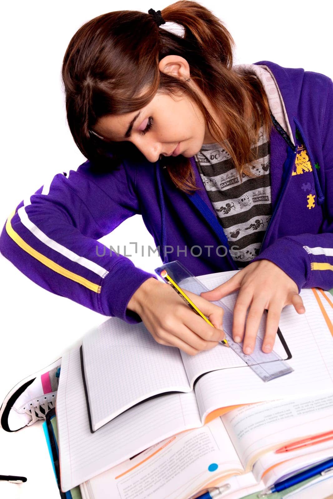 View of a teenager school girl studying on a white background.