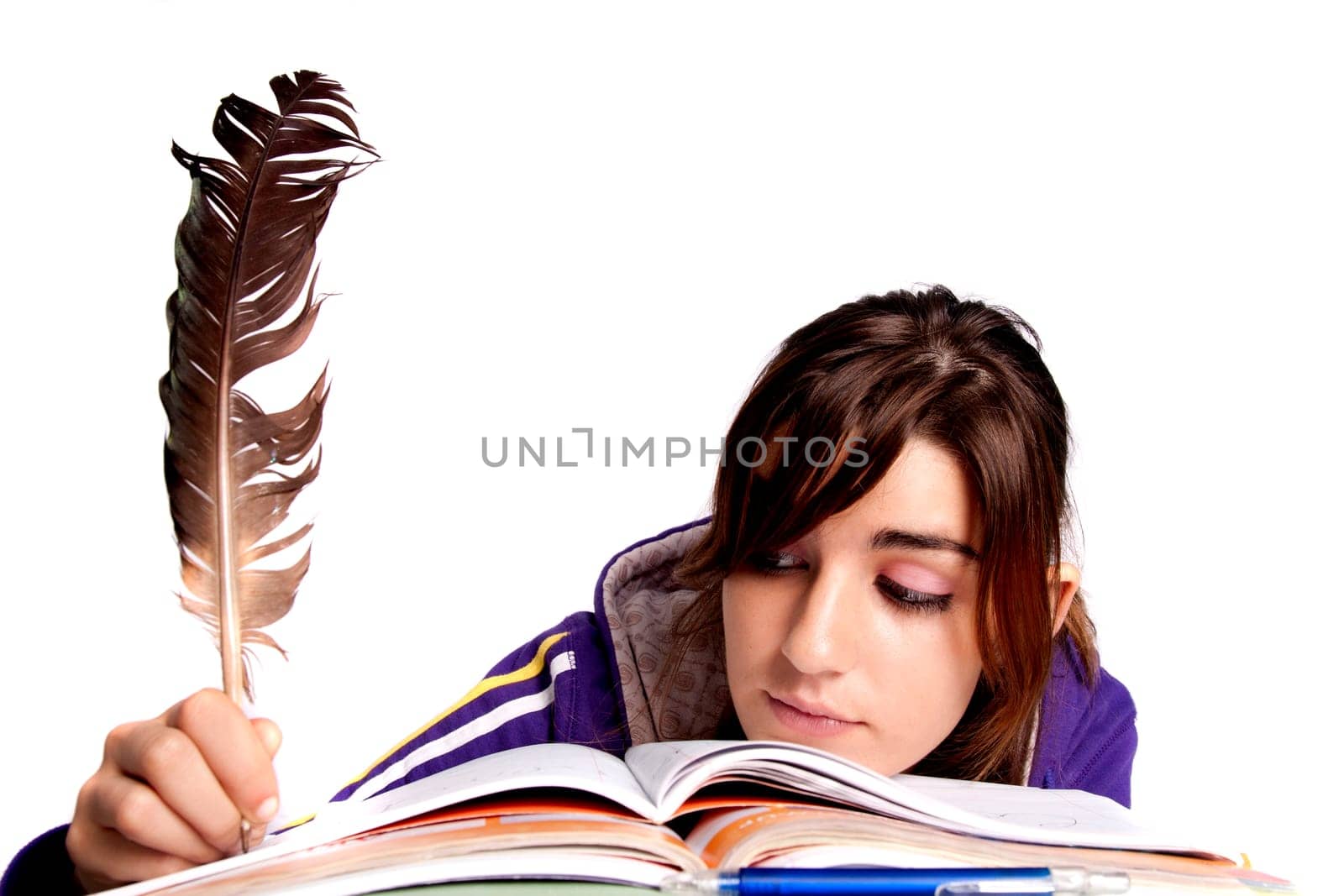 View of a teenager school girl writing on the book with a feather pen.