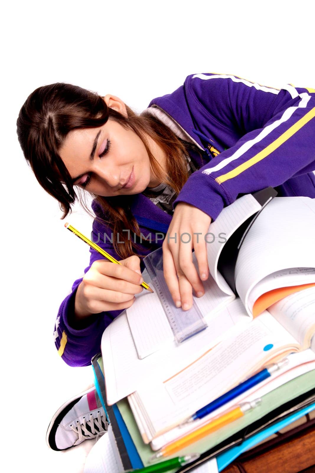 View of a teenager school girl studying on a white background.