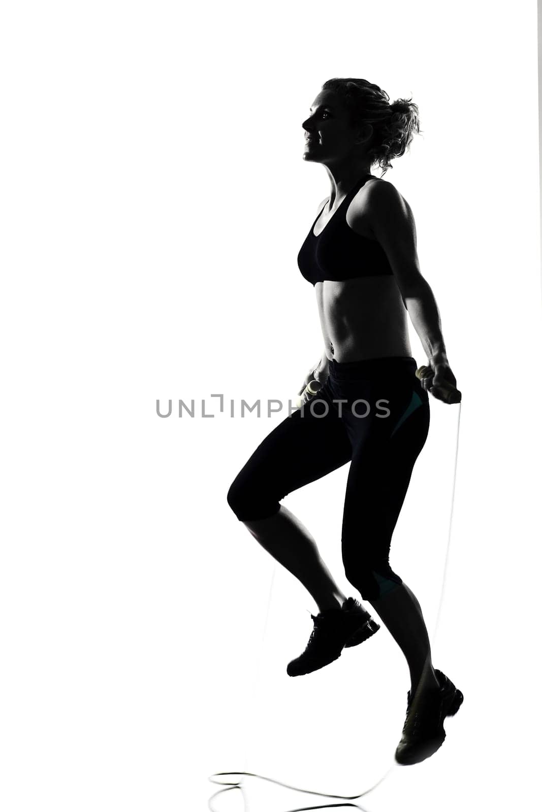 woman workout fitness posture body building jumping rope exercise exercising on studio isolated white background