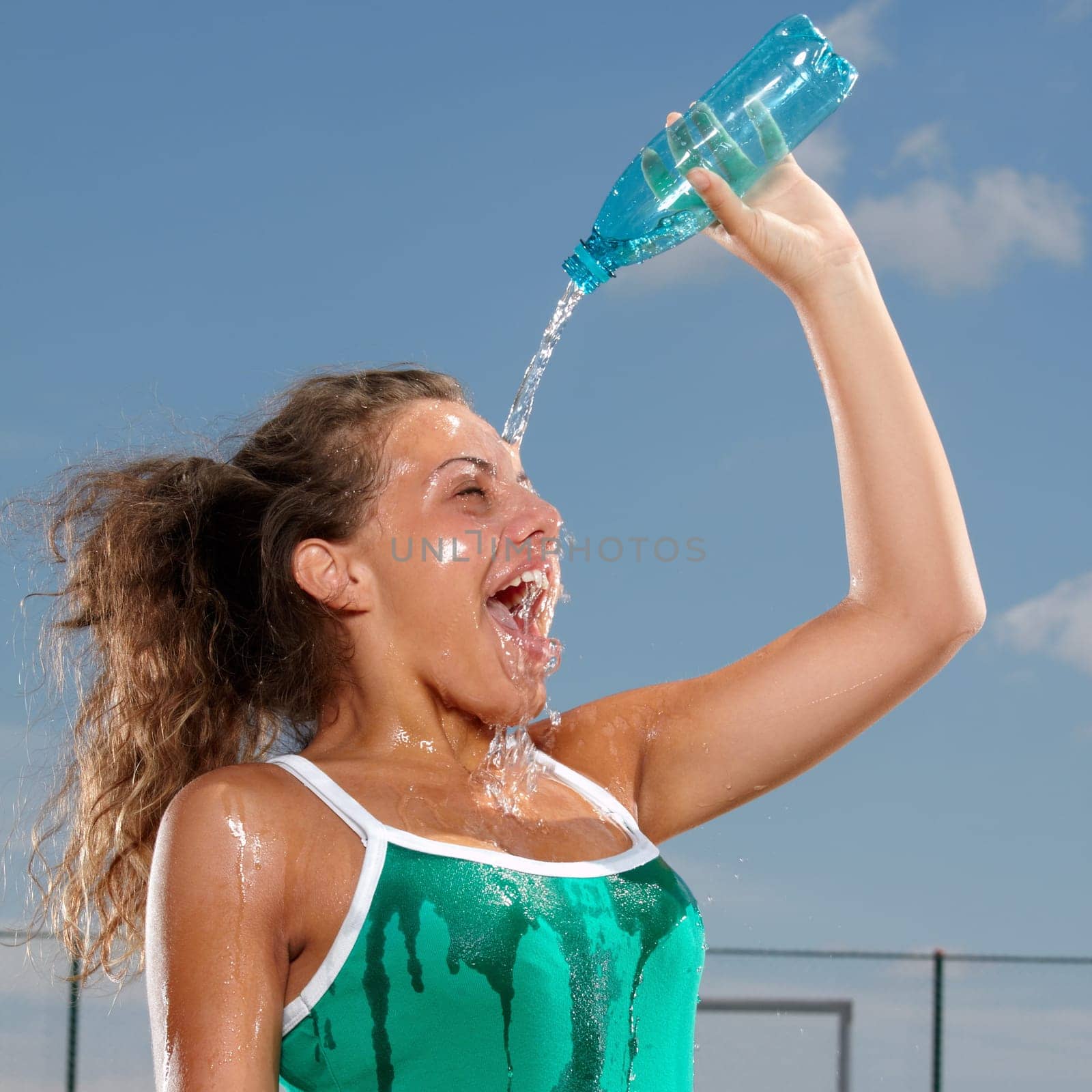 Young woman splashing herself with water to cool herself