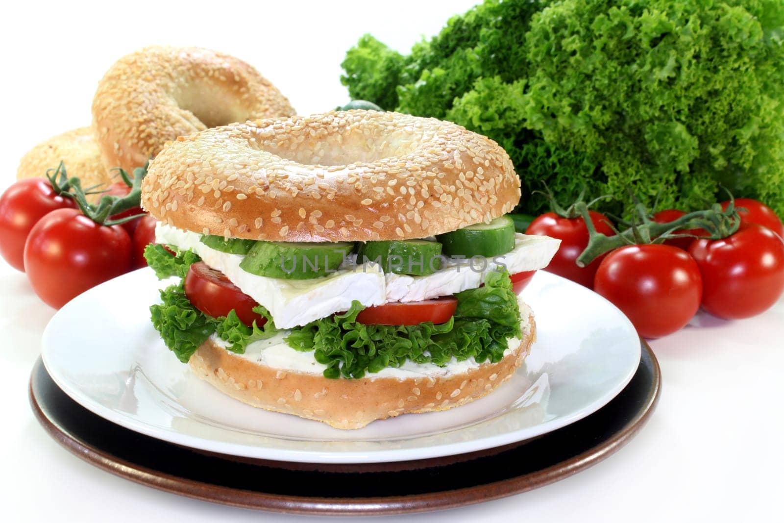 a bagel topped with camembert,cucumber and tomato