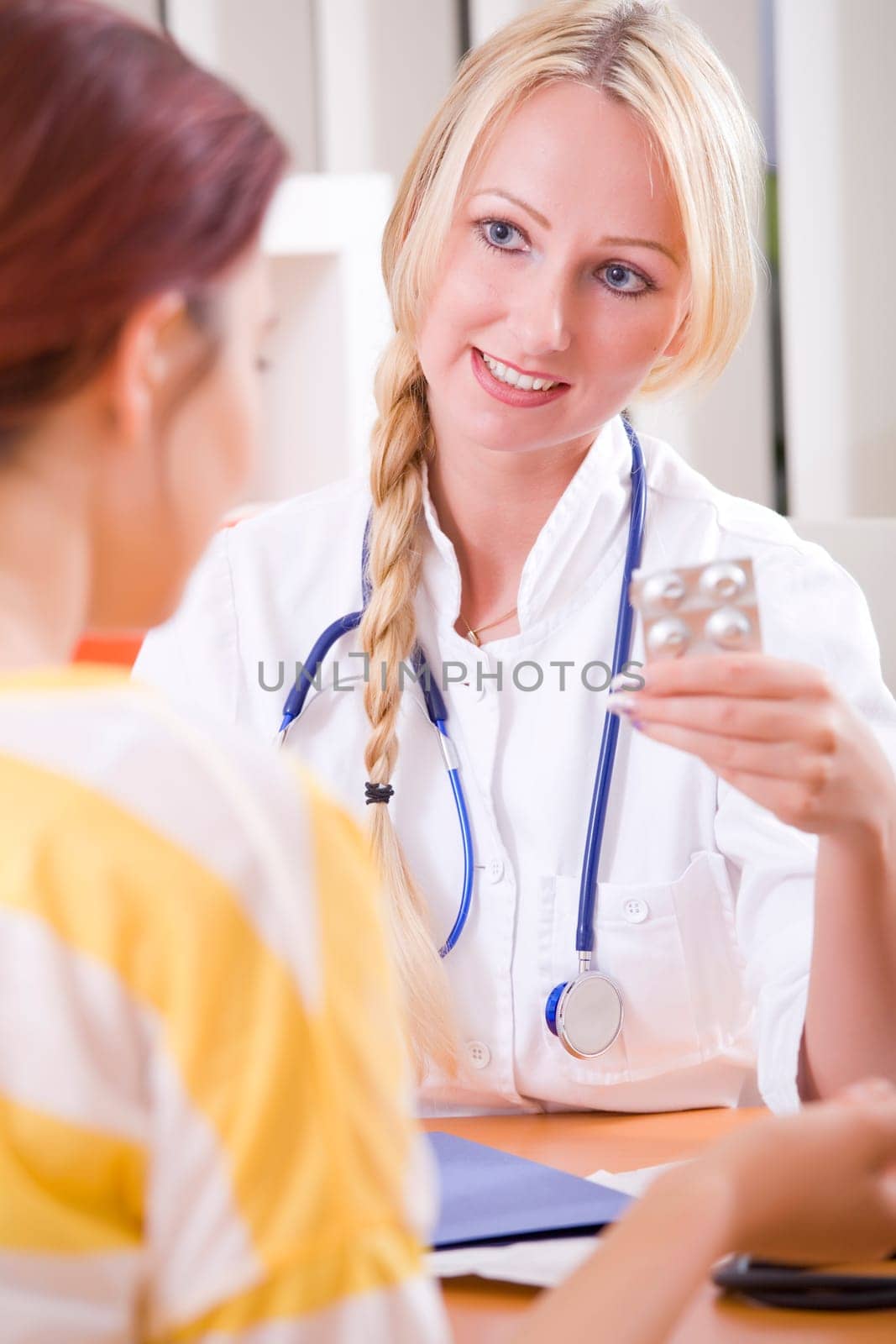 woman doctor holding pills and talking to patient