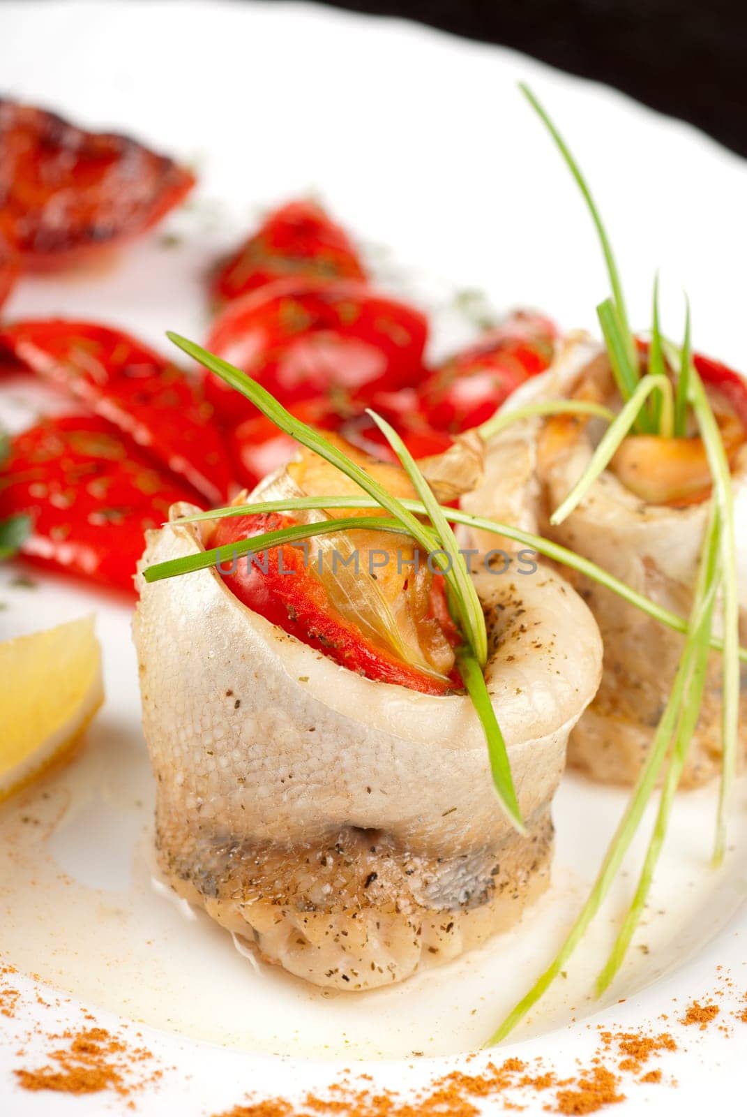 fillet of pikeperch stuffed with trout fish with baked pepper, tomato and leek