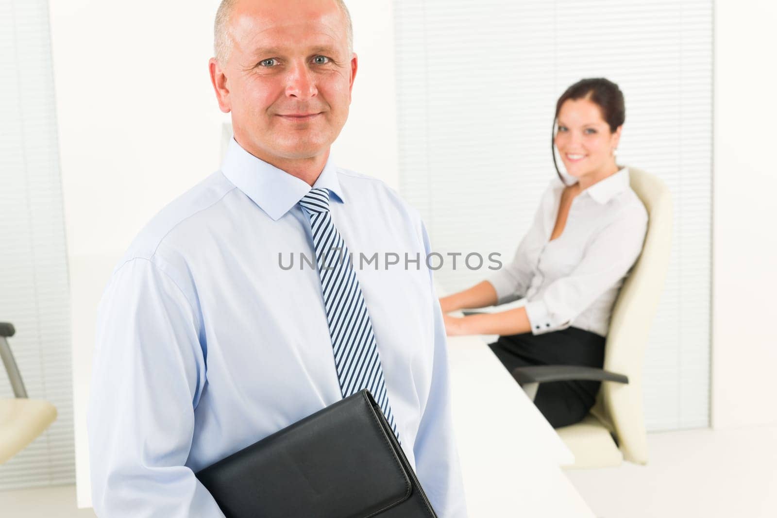 Professional senior businessman hold briefcase in office with attractive secretary