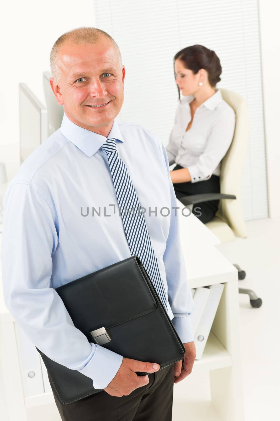 Professional senior businessman hold briefcase in office with attractive secretary