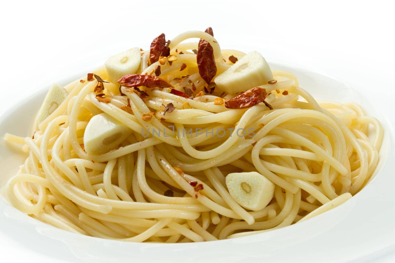 pasta garlic olive oil and red chili pepper closeup on a white dish