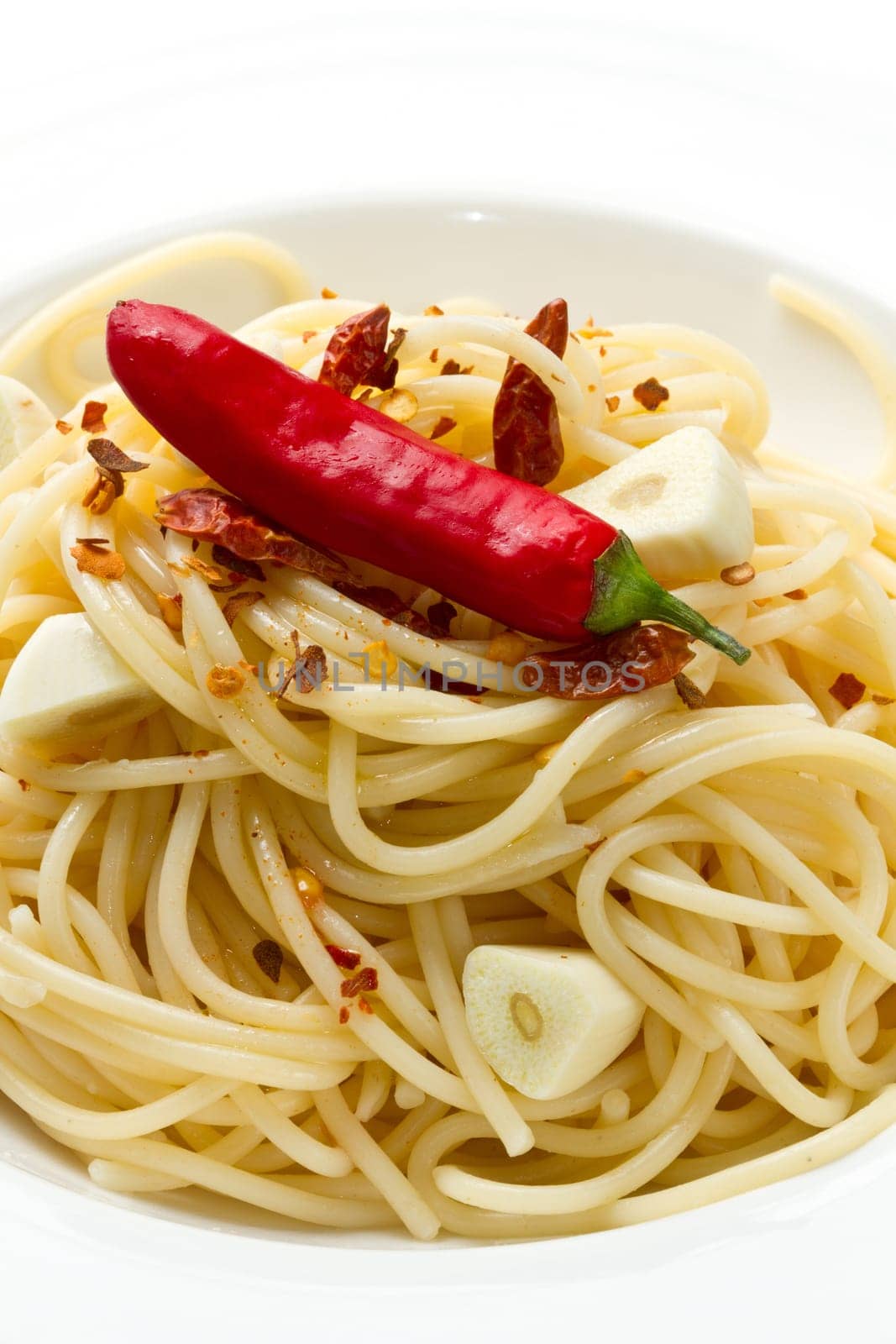 pasta garlic olive oil and red chili pepper closeup on a white dish