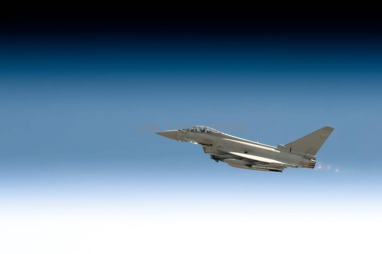 military fighter jet powering through a gradient sky