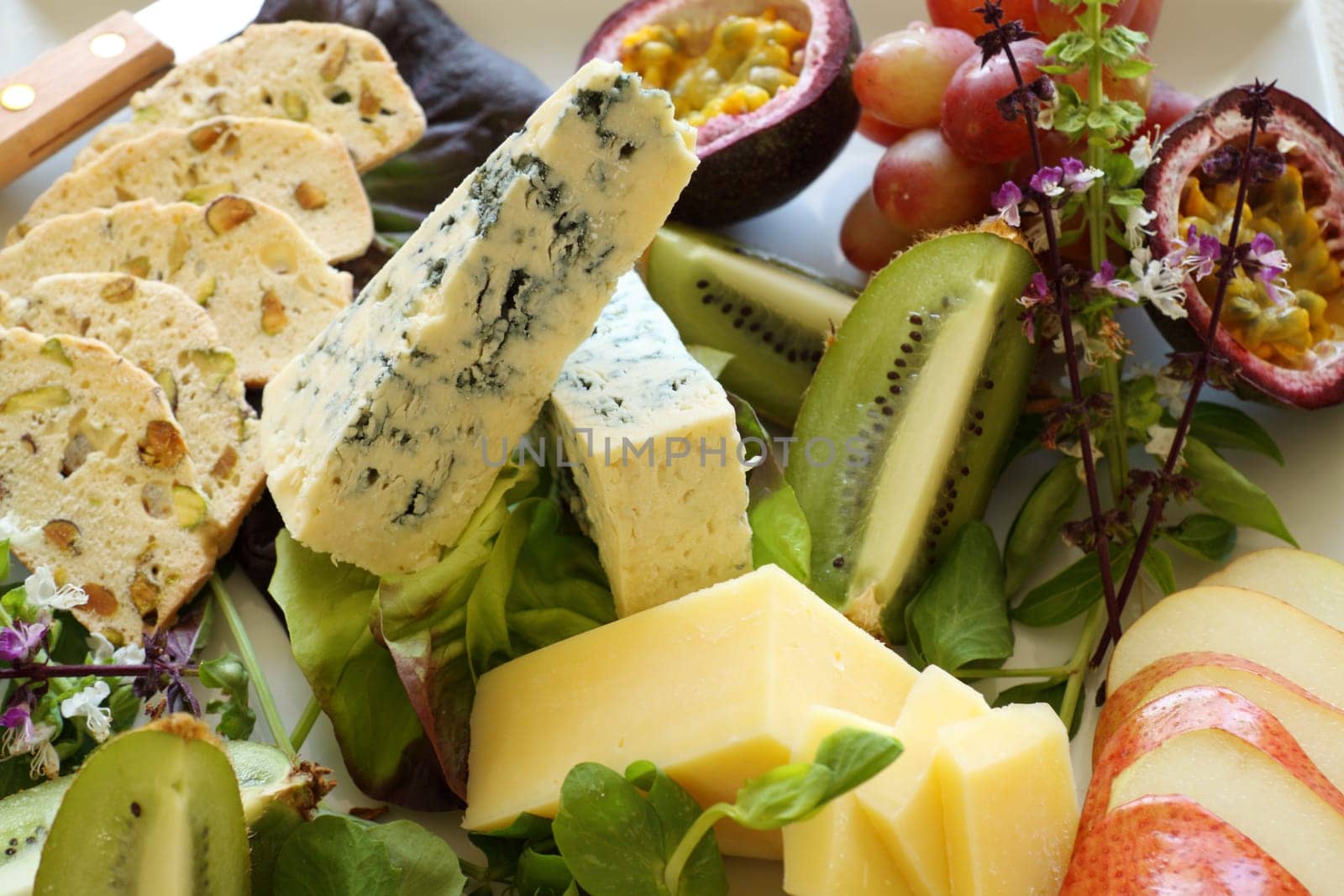 Delicious fruit and cheese platter featuring a variety of different cheeses and fresh fruits.
