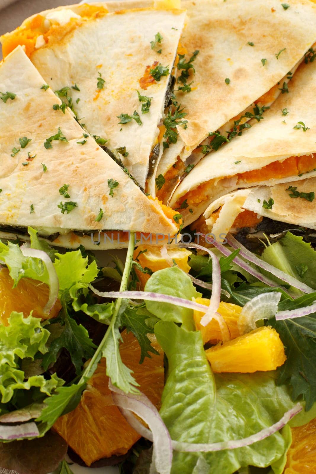 Delicious pumpkin quesadilla sliced and ready to serve with a garden salad.