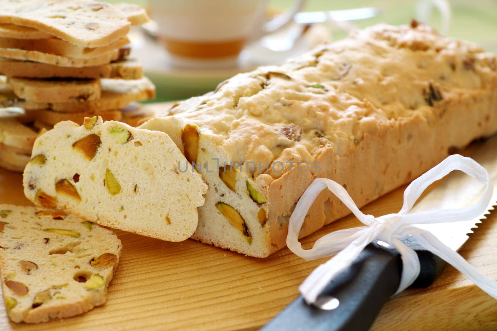 Fresh baked sweet pistachio bread sliced on a bread board with coffee.