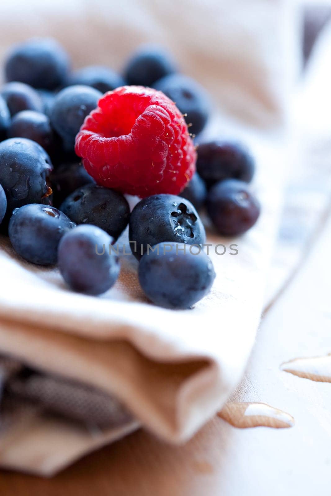Close-up of delicious fresh blueberries and raspberry. Studio shot.
