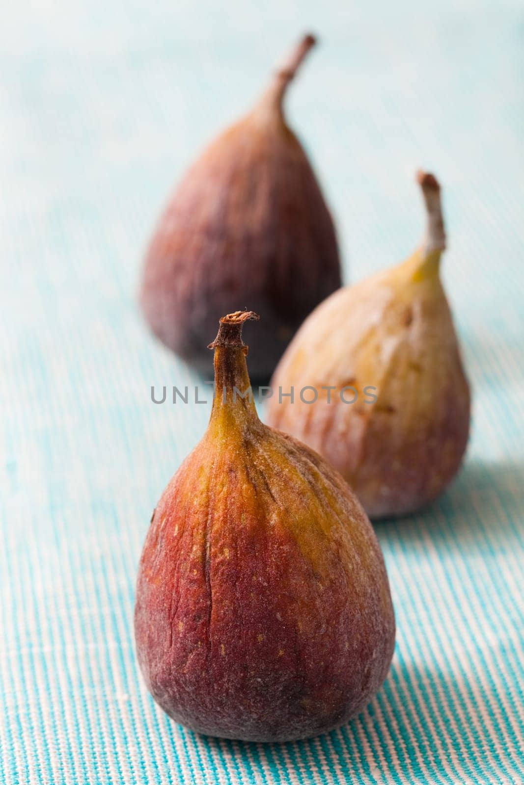 Delicious fresh figs on a blue background. Studio shot.