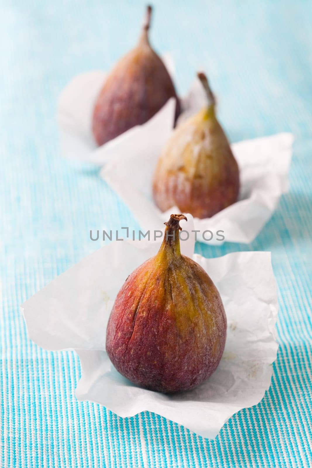 Delicious fresh figs on a blue background. Studio shot.