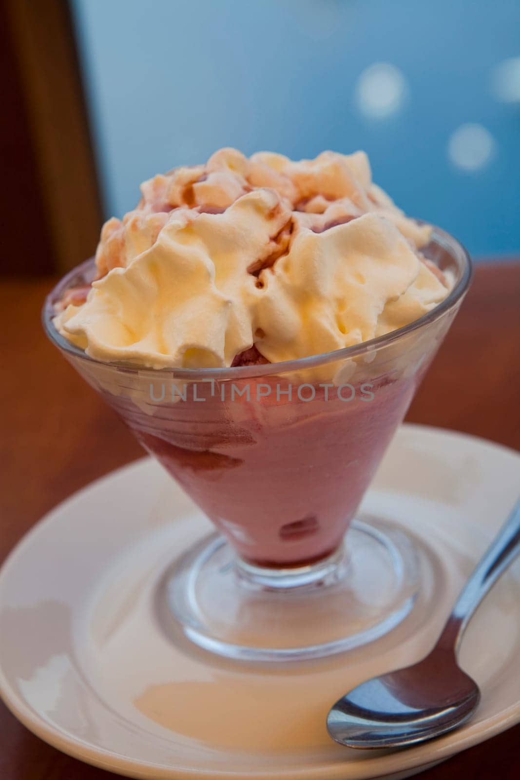 A delicious bowl of strawberry ice cream with whipped cream on top.
