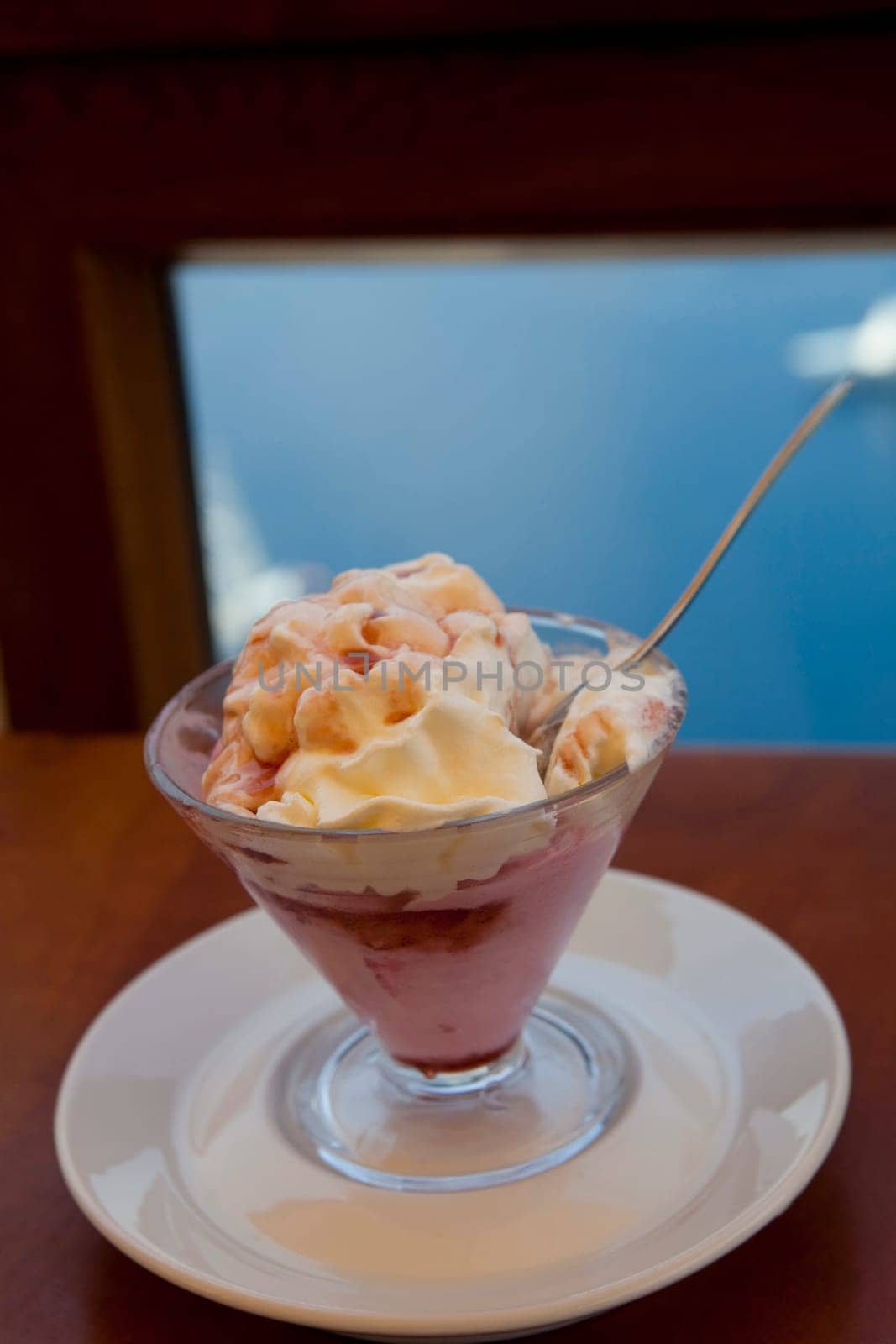 A delicious bowl of strawberry ice cream with whipped cream on top.