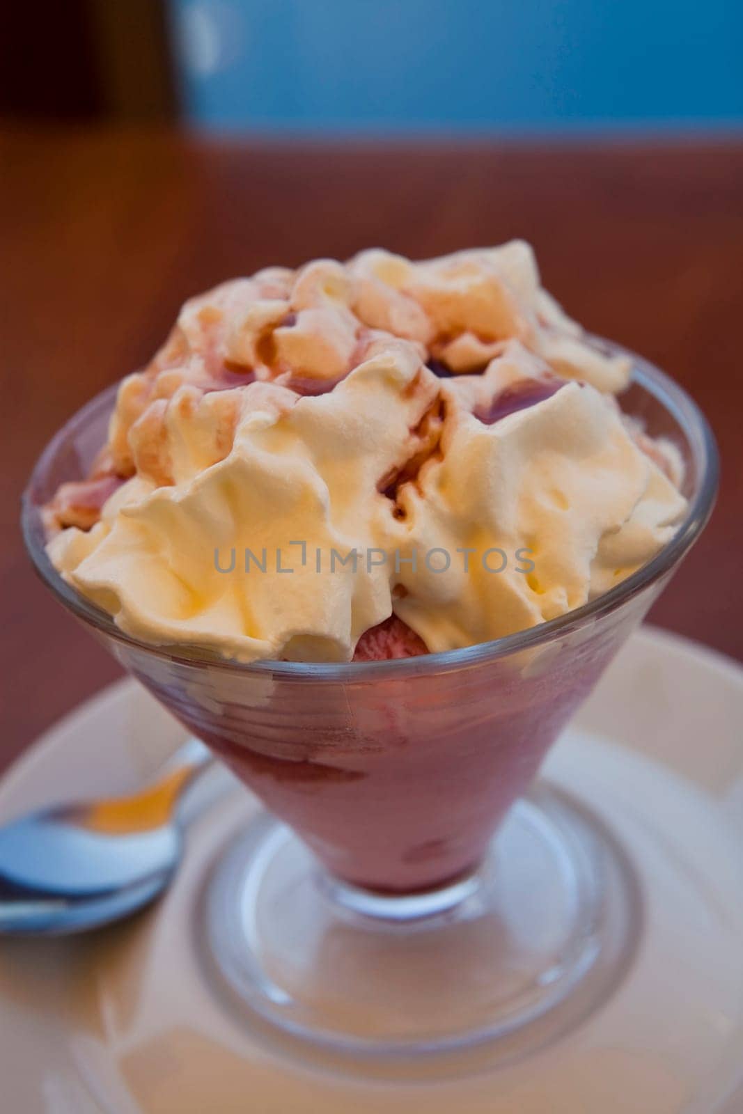 A delicious bowl of strawberry ice cream with whipped cream on top.