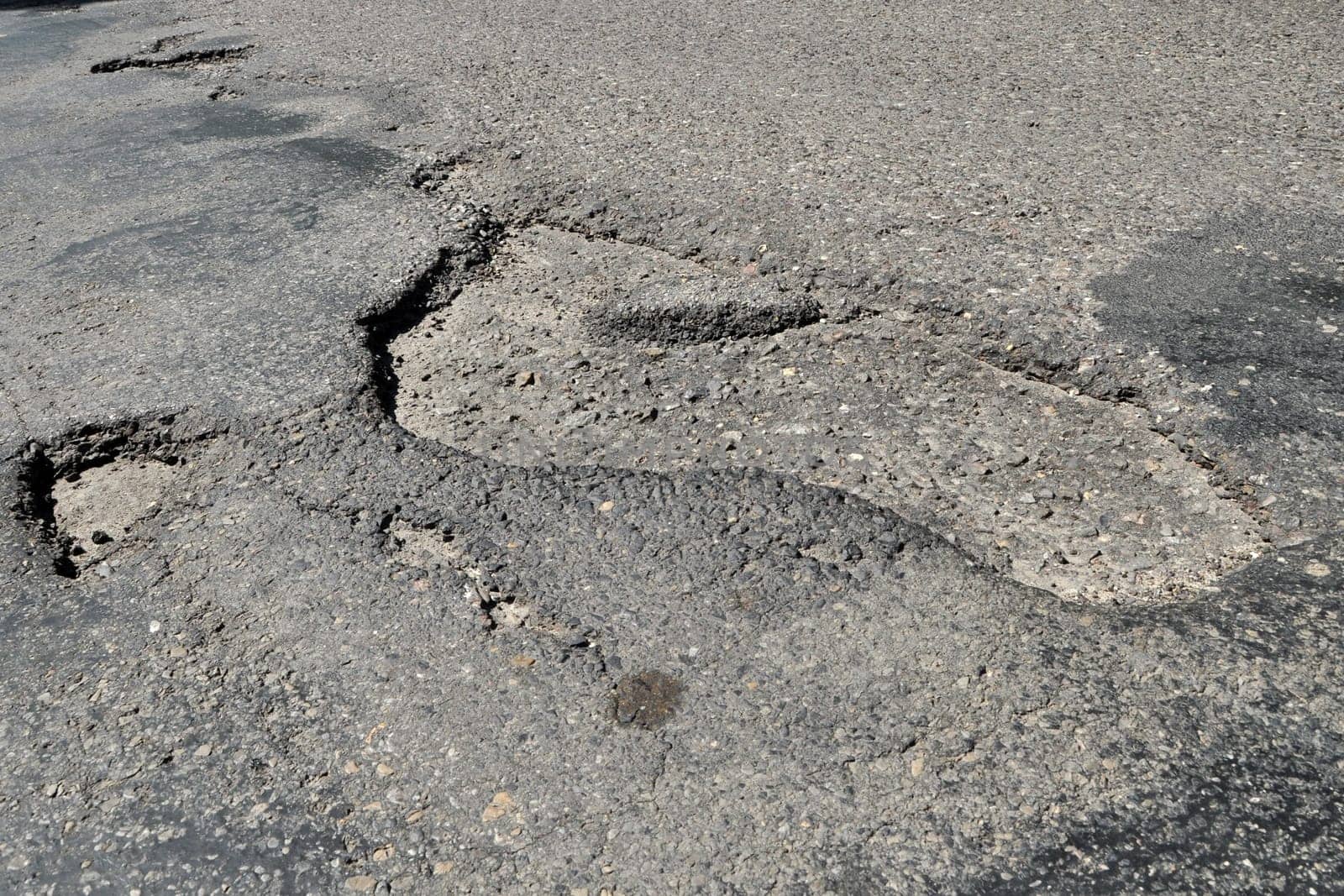 road destroyed after winter. a hole in the road.