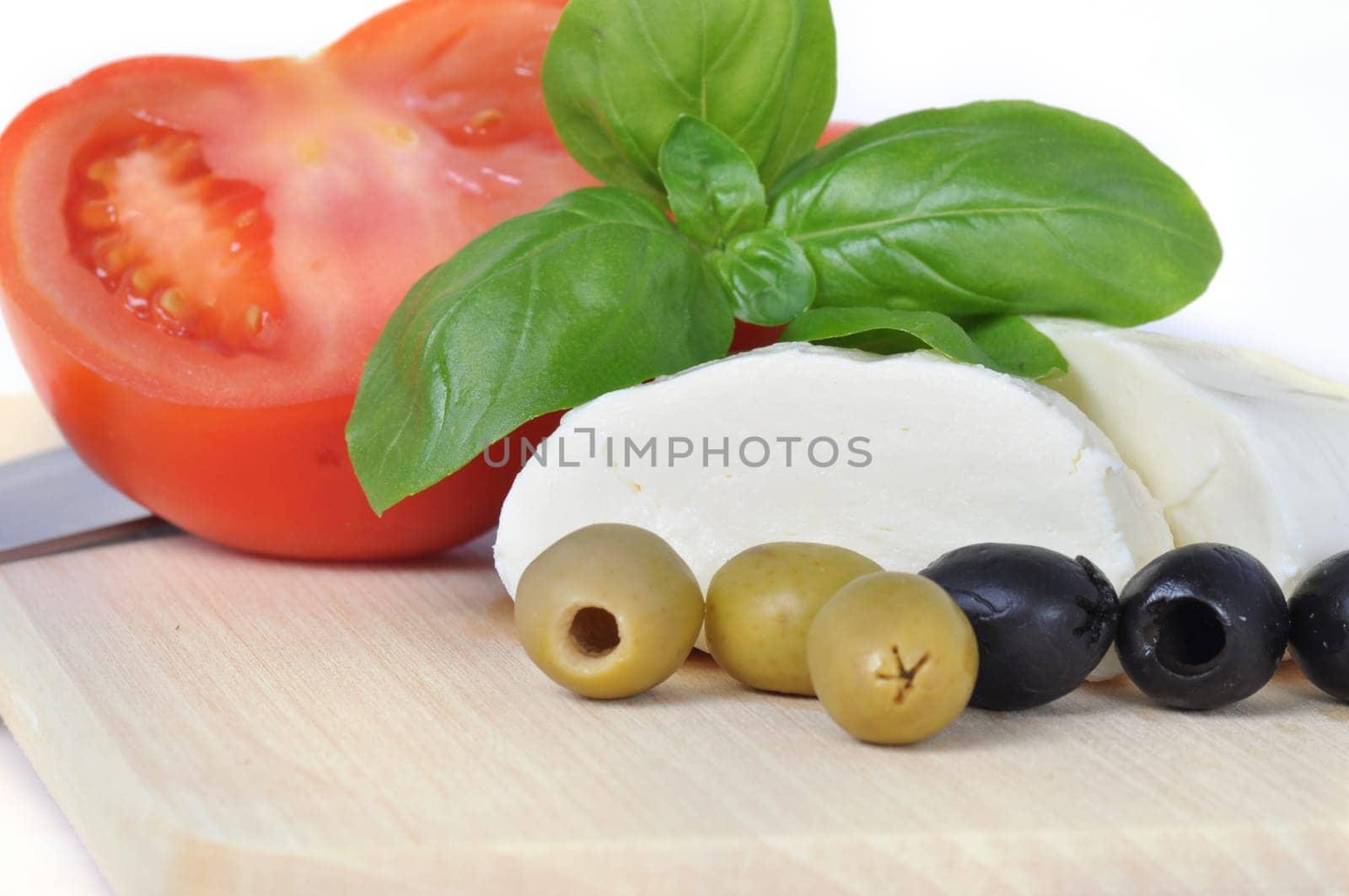 sliced \u200b\u200bmozarella cheese with basil,tomato and olives isolated on white background.