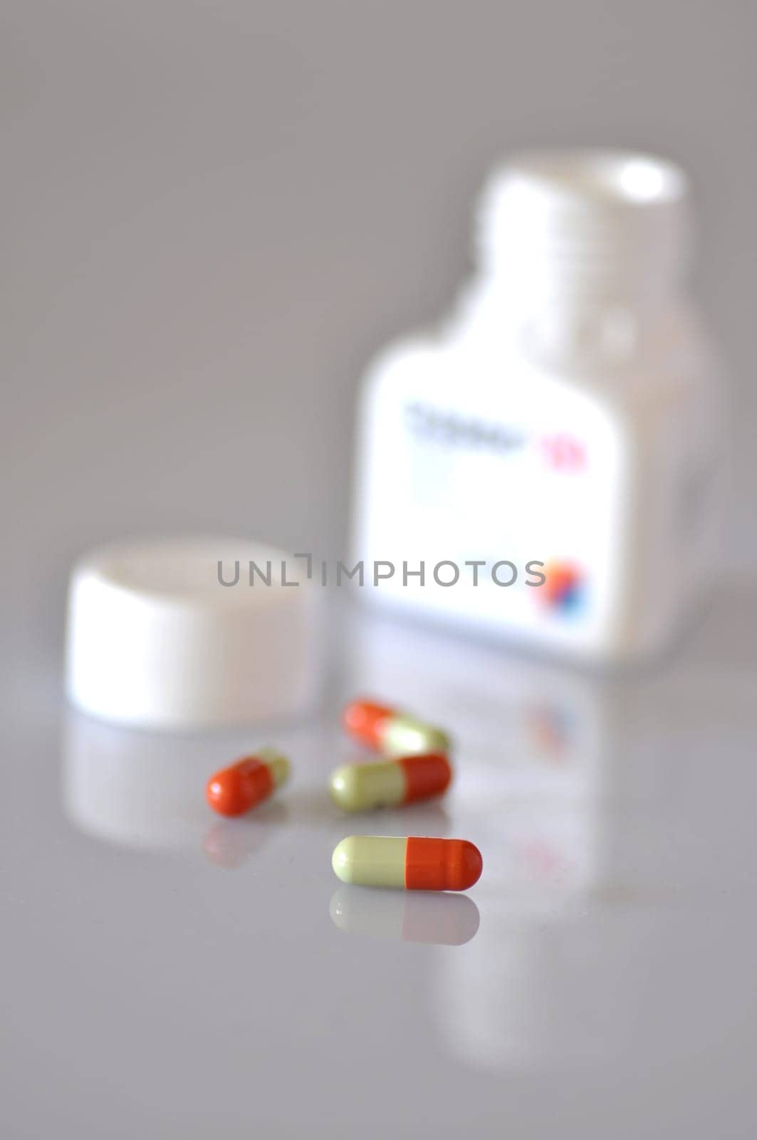 colourful capsules spilling from a plastic bottle