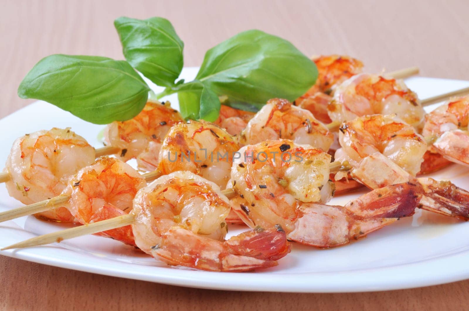 shish kebab from shrimps on dish with basil