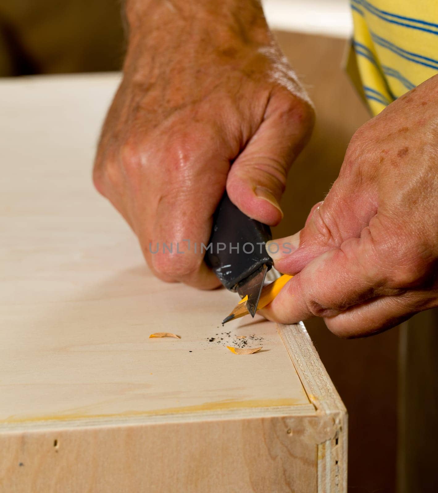 Box cutter being used to sharpen a carpenter&#039 s pencil