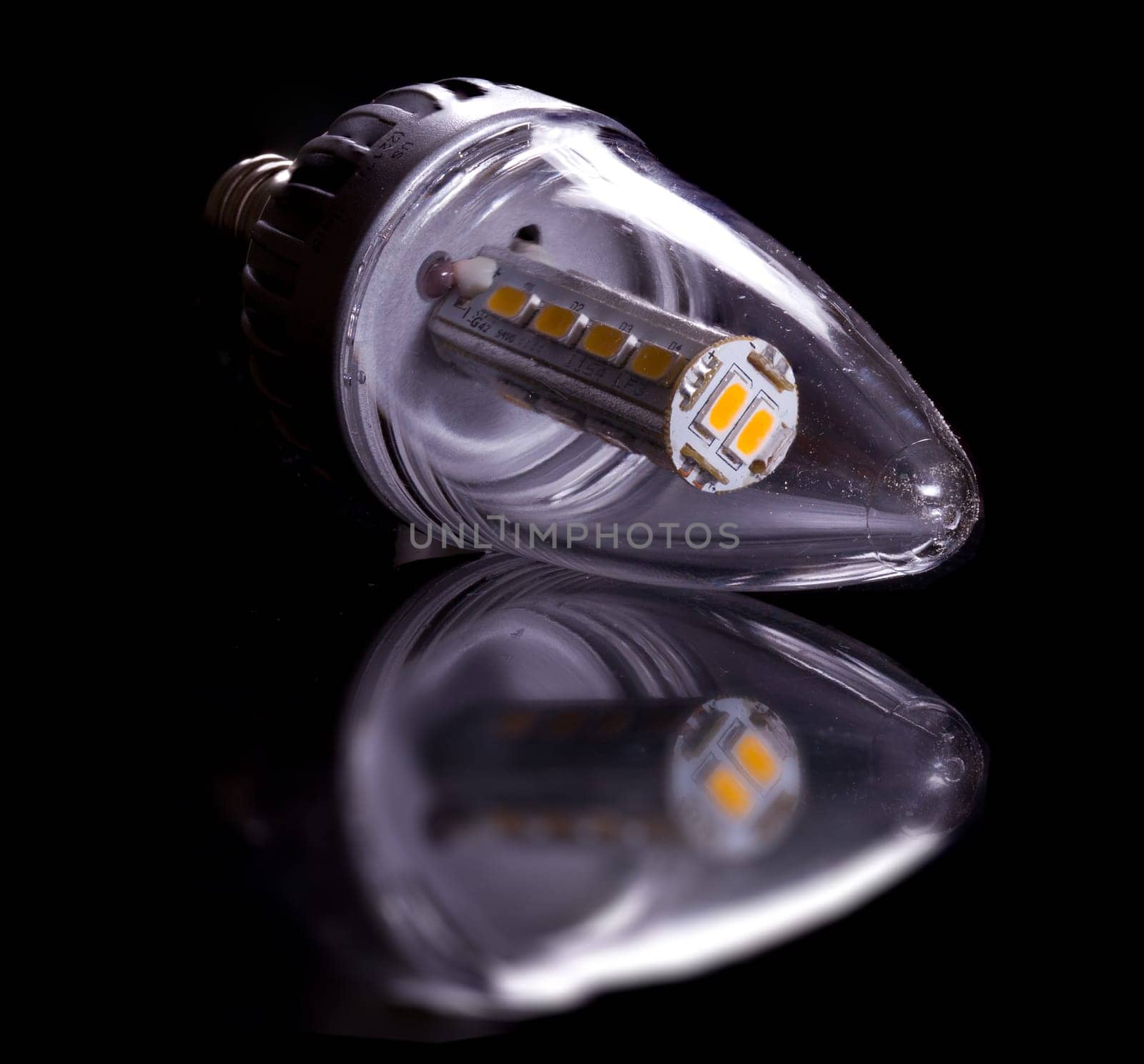 Latest LED light bulb in candle shape and reflecting off a black surface