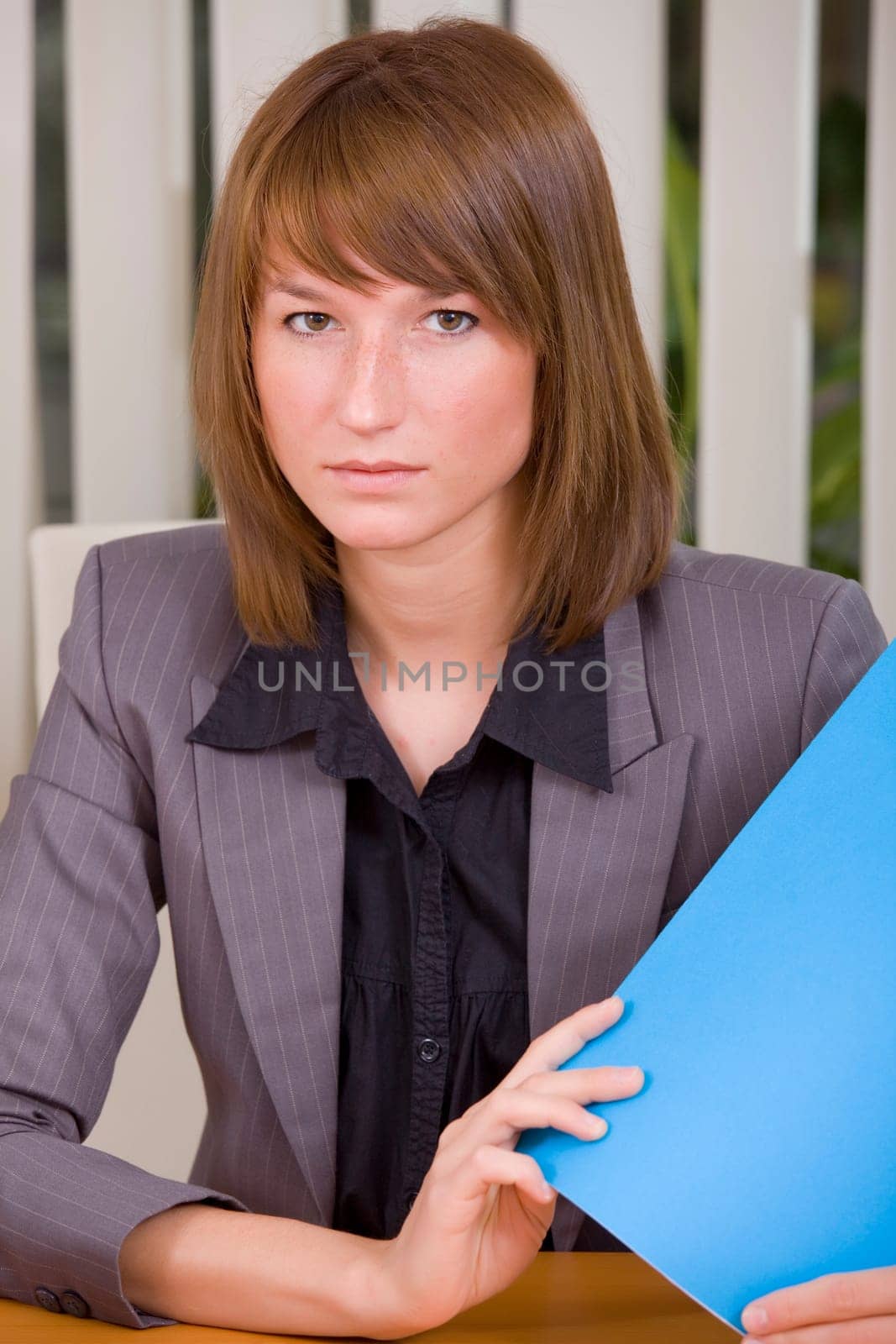 portrait of businesswoman holding a file in office