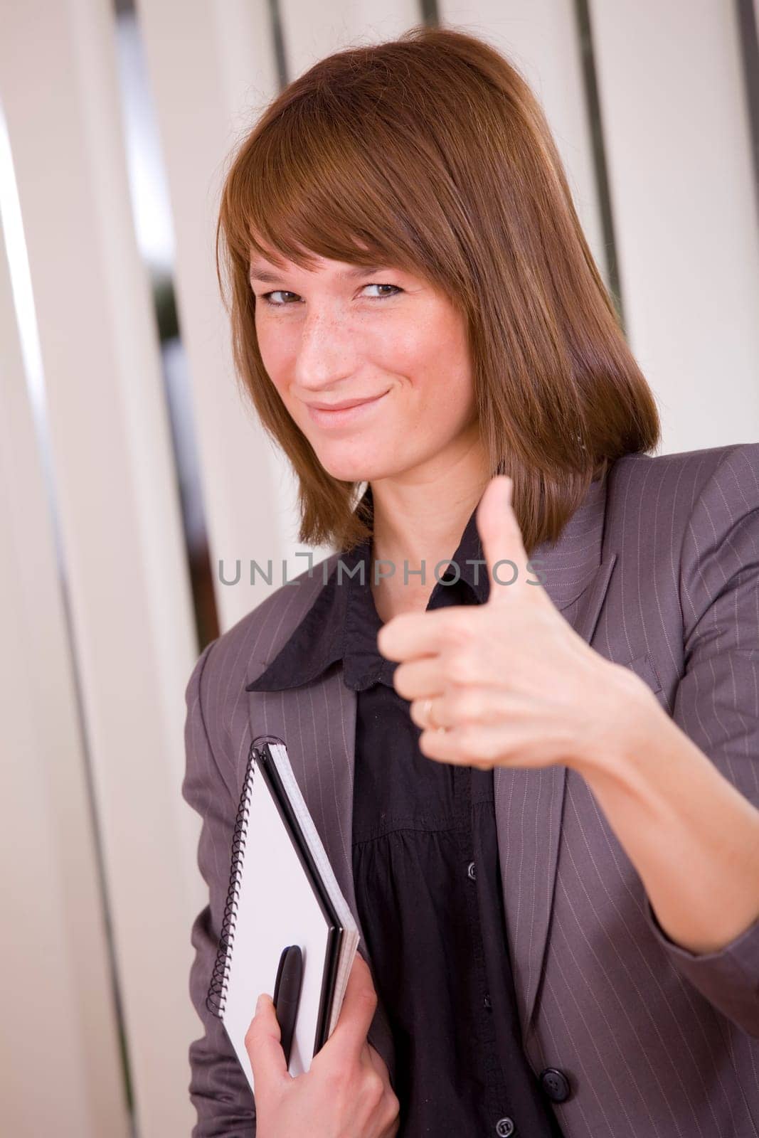 happy businesswoman with thumb up in office