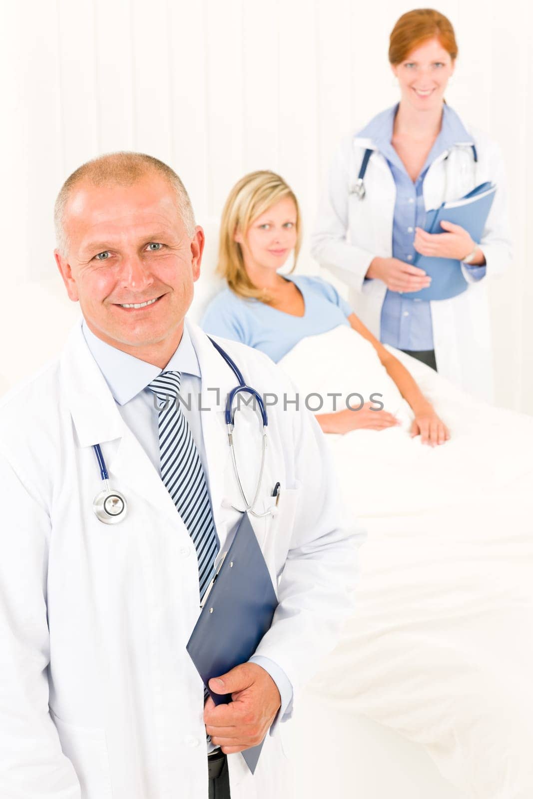 Two medical doctors professional with hospital patient lying in bed