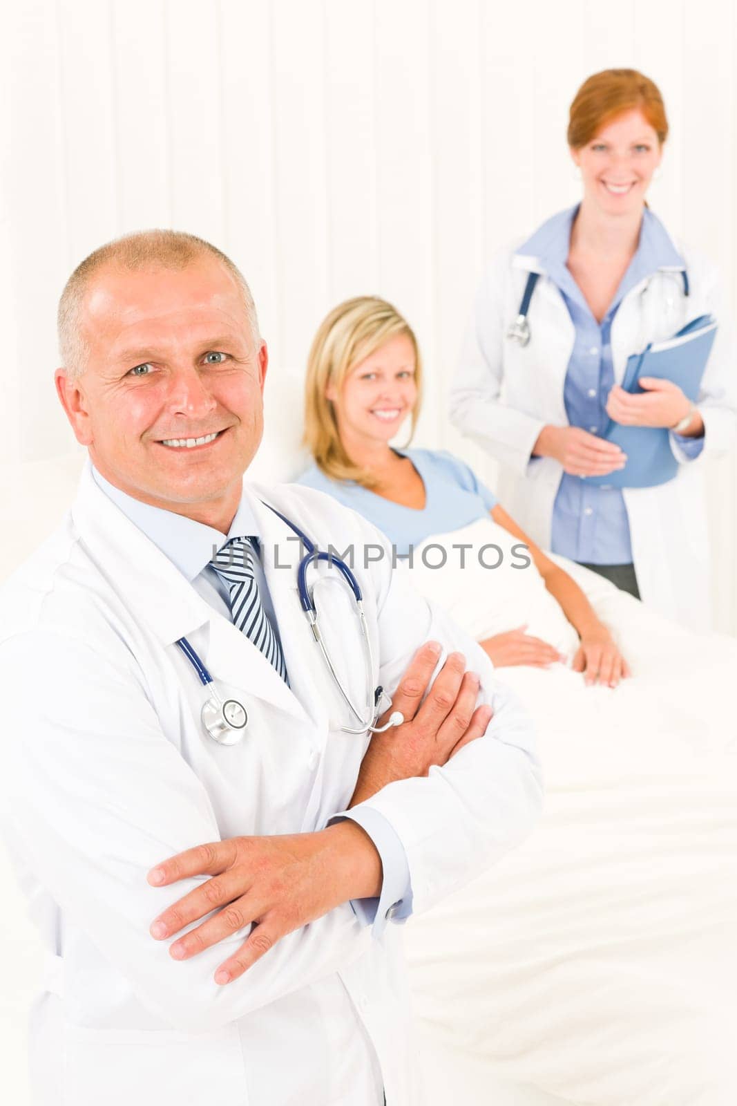 Two medical doctors professional with hospital patient lying in bed