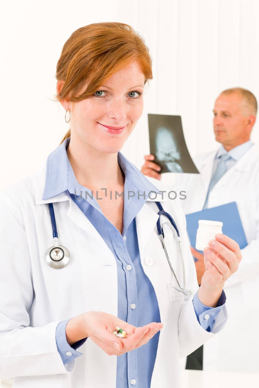 Medical doctor team young woman holding pills male senior colleague
