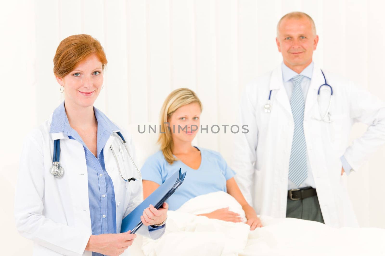 Two medical doctors professional with hospital patient lying in bed
