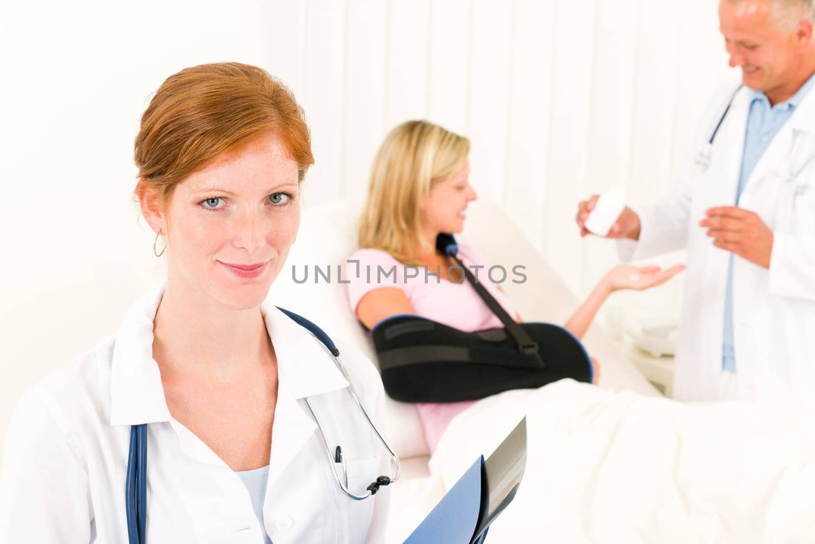 Medical doctors give pills hospital patient in bed broken arm