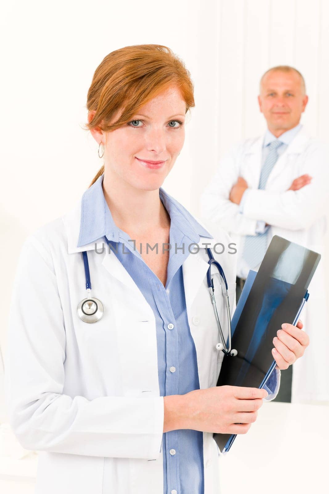 Medical doctor team young woman holding x-ray senior male colleague