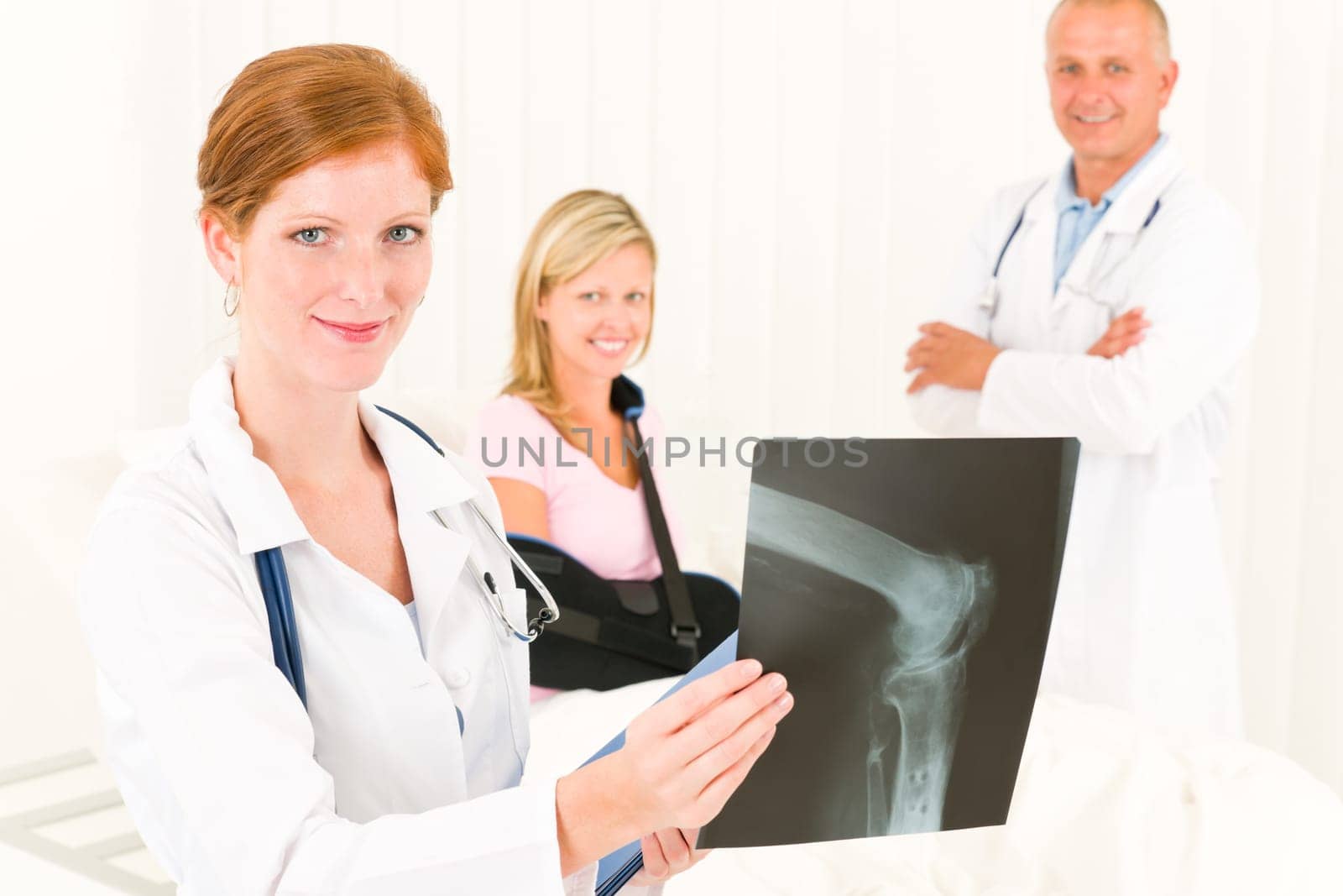 Medical doctors show x-ray hospital patient in bed broken arm