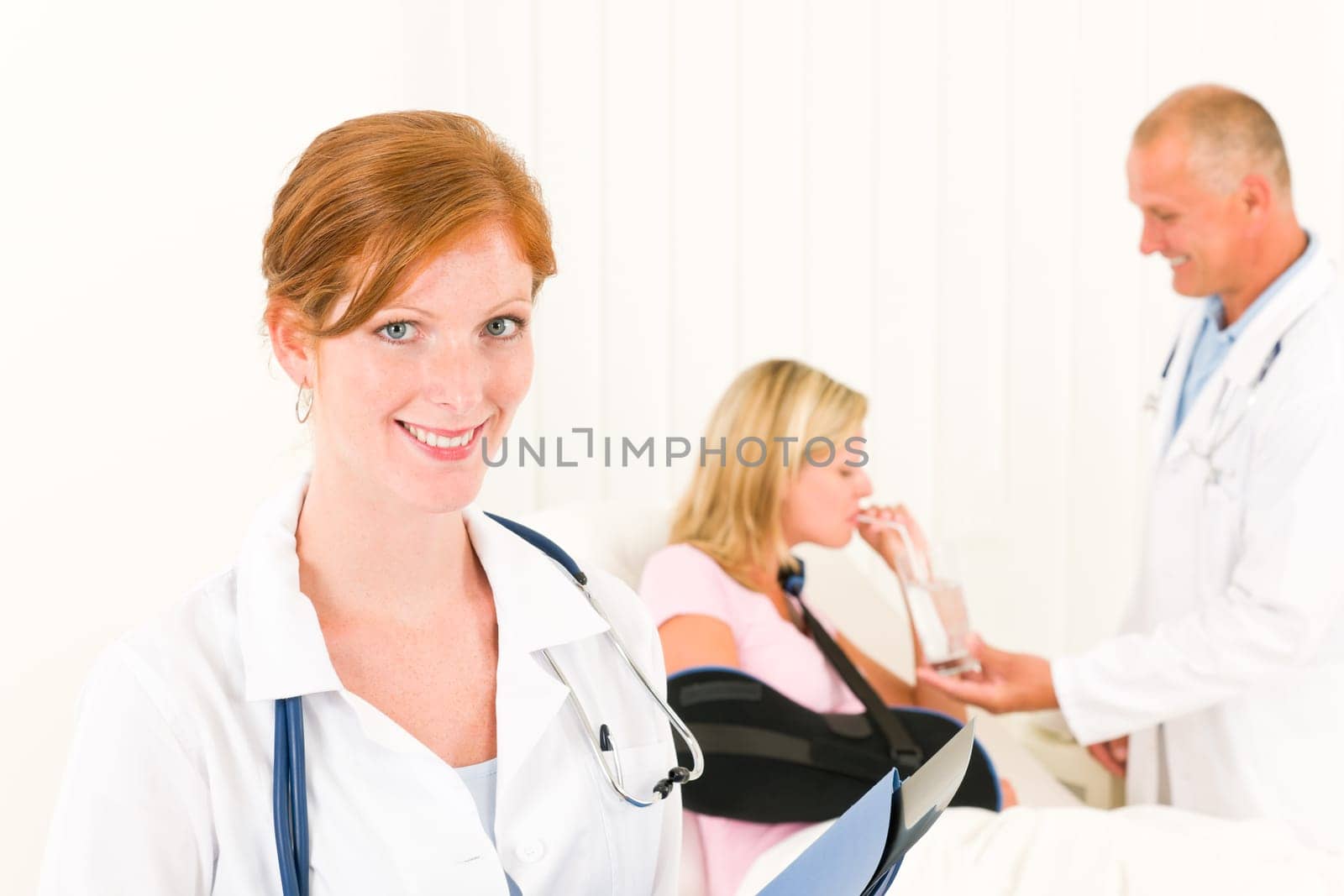 Medical doctors give drink hospital patient in bed broken arm