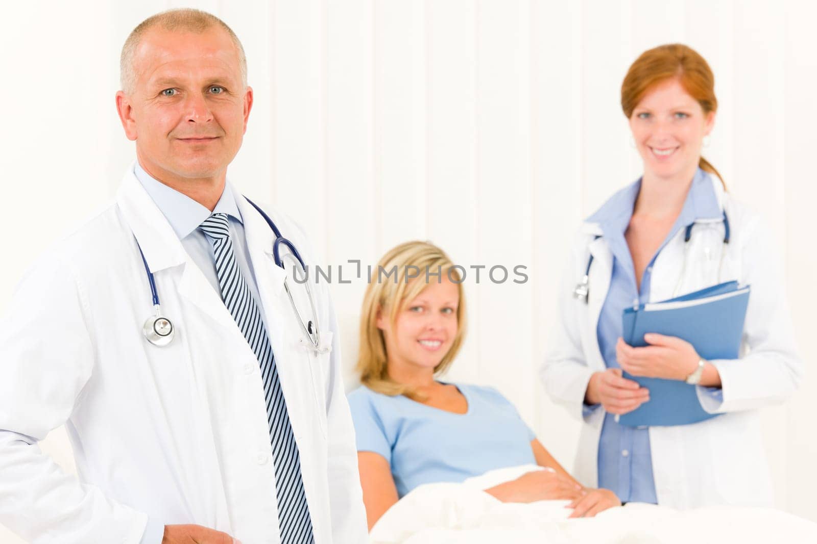 Two medical doctors professional with hospital patient lying in bed